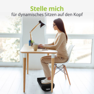 Frau sitzt am Schreibtisch mit feela ergonomischer Fussstütze in schwarz am Boden